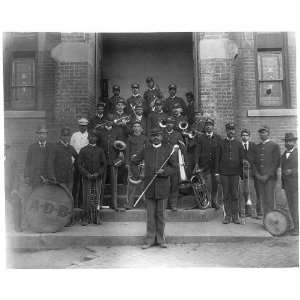 African American band posed on steps to brick building  