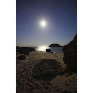  A full moon skyscape over a small beach called Portinho da 