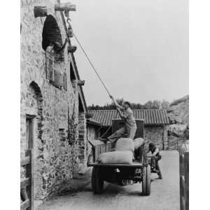   , men loading sacks of grain from truck in courty